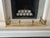 An elegant antique-style brass fireplace fender featuring an ornate neoclassical design with decorative finials, pierced...