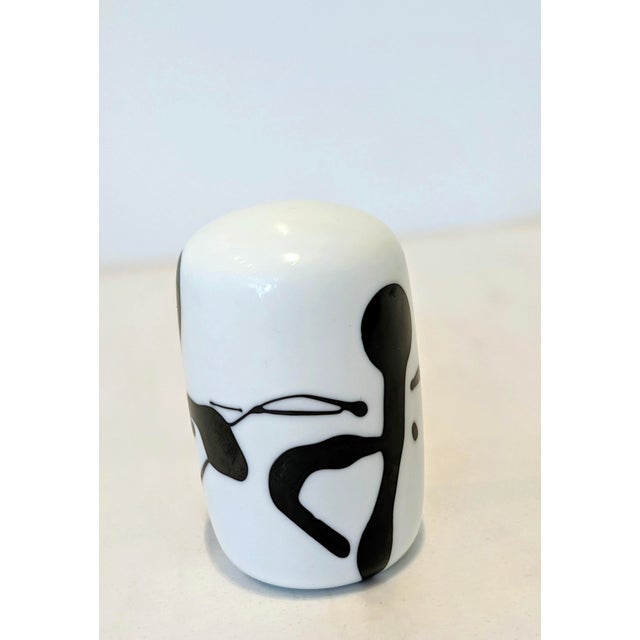 Black figure set in white under thick clear glass, heavy for its size. Probably 1970s to 80s. Marked on the base: NGS, the...
