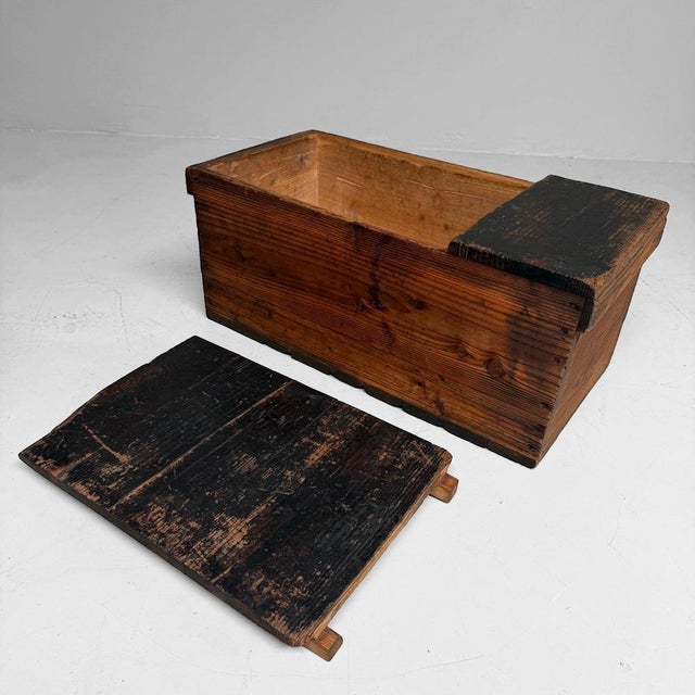 A sober antique Japanese wooden chest with an exceptionally aged surface, warm wood grain, and a deep, natural patina....