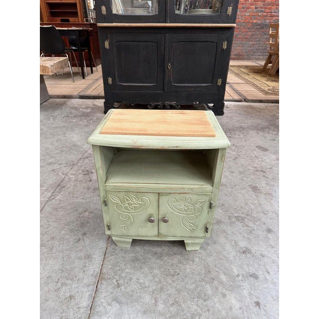 Small patinated Art Deco bedside table, raw wood top It has a niche and solid engraved doors opening onto a storage space....