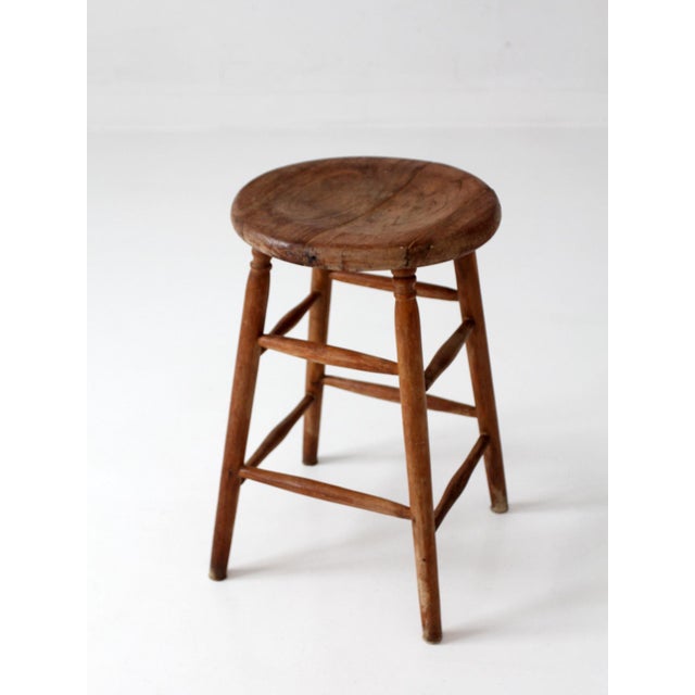 This antique wood stool features a simple country form with warm, primitive character. The gently rounded seat, turned...