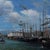 This 20th-century painting on canvas, signed François Nicoli, depicts a bustling harbor where numerous sailing ships with...