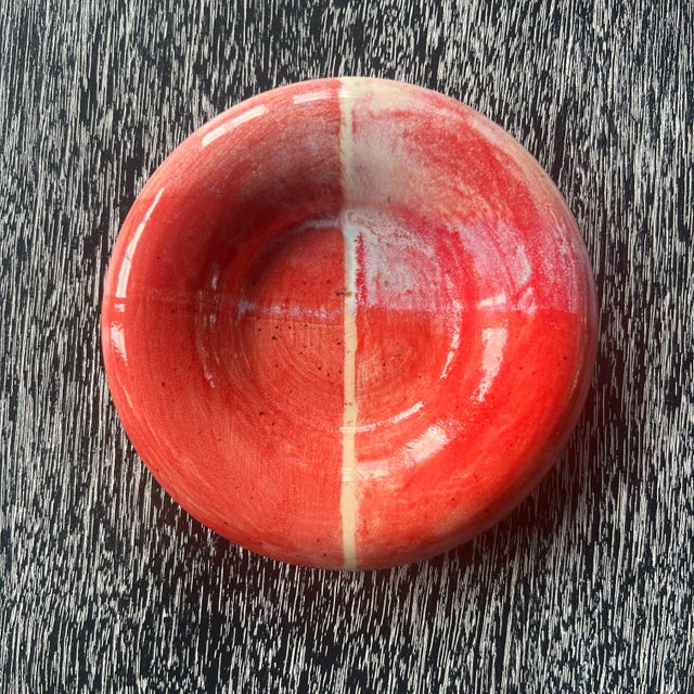 Handmade pottery trinket dish, catchall or coaster. Features a red glaze with decorative details and a rounded rim. Has a...