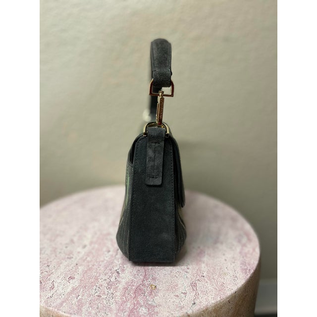 Elevate your accessory collection with this Giorgio Armani Embroidered Suede Handbag, a timeless piece that embodies...