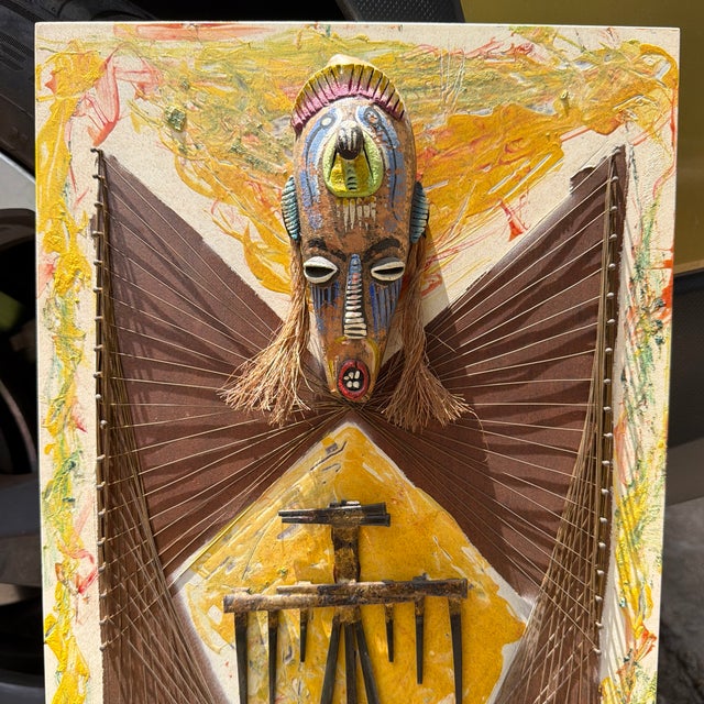 An assemblage of a Nicaraguan decorative mask, nails woven with wire, antique iron nails, and some sort of very thick...
