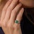 This elegant vintage three stone ring showcases a vivid emerald cut emerald weighing 1.84 carats, offering a rich green...
