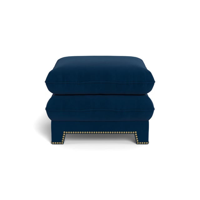A dreamy, cloud-like upholstered pouf with tapered legs and French nailhead trim. An inviting pull-up ottoman - a pair of...