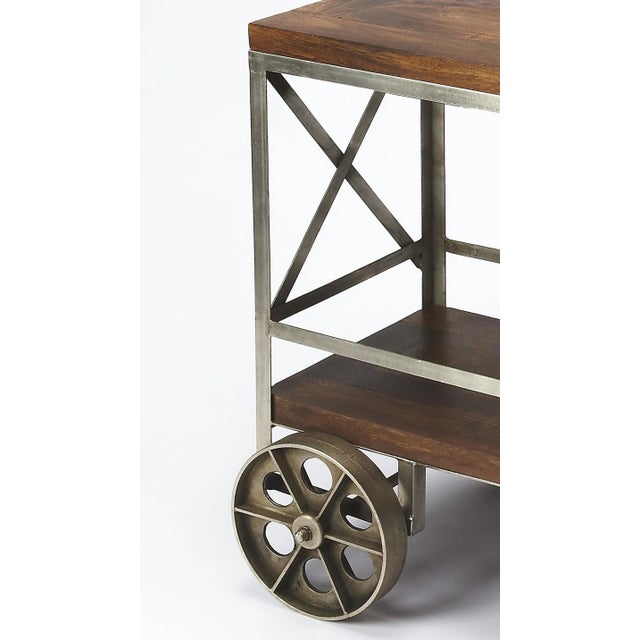 Serve guests in style with this modern industrial trolley cart. Forged from iron, its frame has a zinc silver finish with...