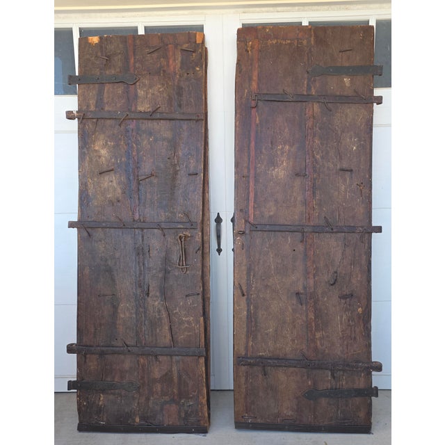Great looking very heavy rustic doors with old hand forged iron hinges . Each one is 30.5" wide making the pair 61"wide.