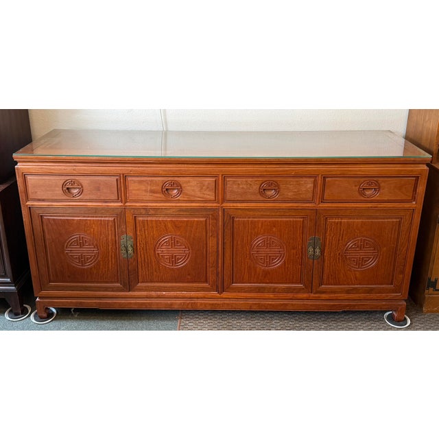 Design Plus Gallery presents a Chinese Ming Style Cabinet in Rosewood. The upper hutch has four glass doors, glass...