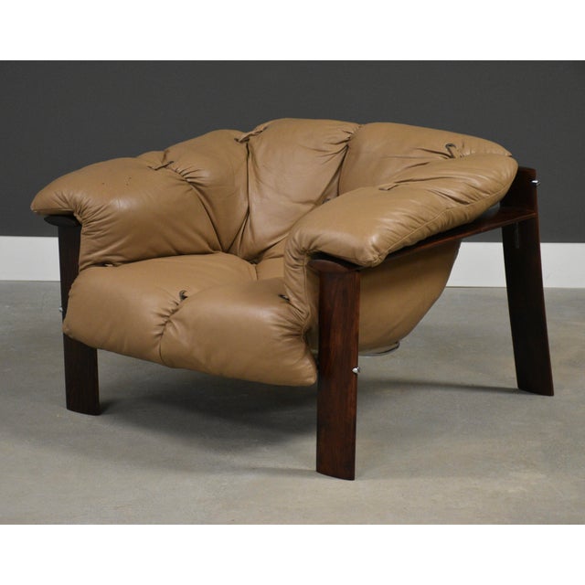 A mid century modern light brown leather lounge chair designed by Percival Lafer with a rosewood like Jacaranda frame....