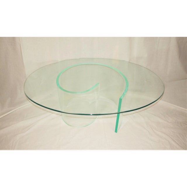 An abstract Lucite design coffee table with oval glass. Thick Lucite ¾” shaped into a coil. Oval glass completes the look....