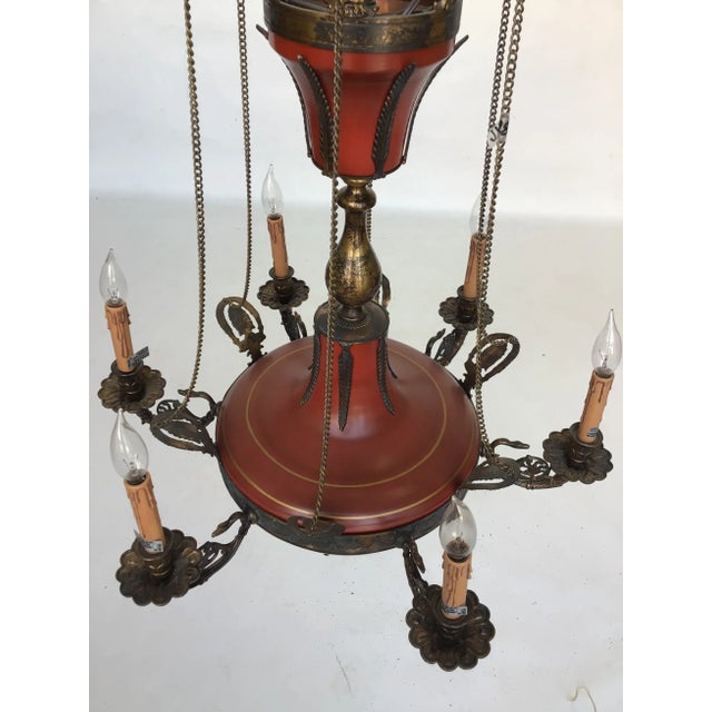 Gorgeous six light brass chandelier with antique red tole finish featuring detailed leaf cut-outs at the top. Created in...