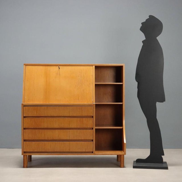 Italian-made furniture from the 1960s, crafted from maple veneer. The clean, functional design features a drop-leaf door...