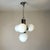 Striking vintage Space Age chandelier featuring four spherical white opaline glass globes arranged around a polished...