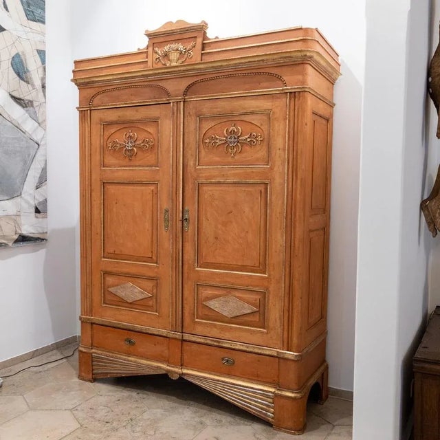 Large beveled cabinet with two doors and two drawers and gold and silver patinated stucco decorations in the form of vines...