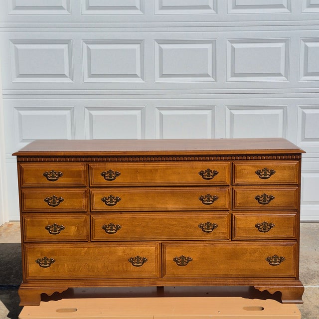 This is a 1960s early colonial style solid maple dresser and matching mirror, which Leo Jiranek designed for Bassett...
