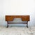 Constructed in teak, with two banks of drawers flanking a central kneehole, raised on the range's distinctive curved,...