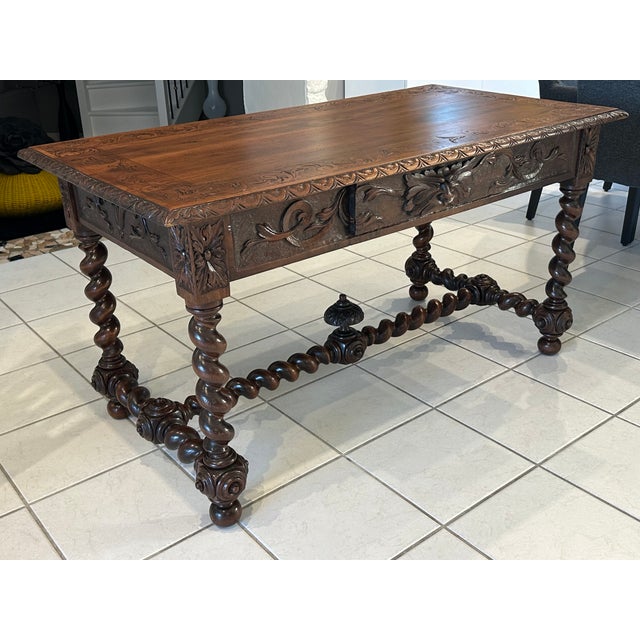 A very fine Louis XIII style desk in solid walnut from the early 19th century, intricately carved on all sides. It rests...