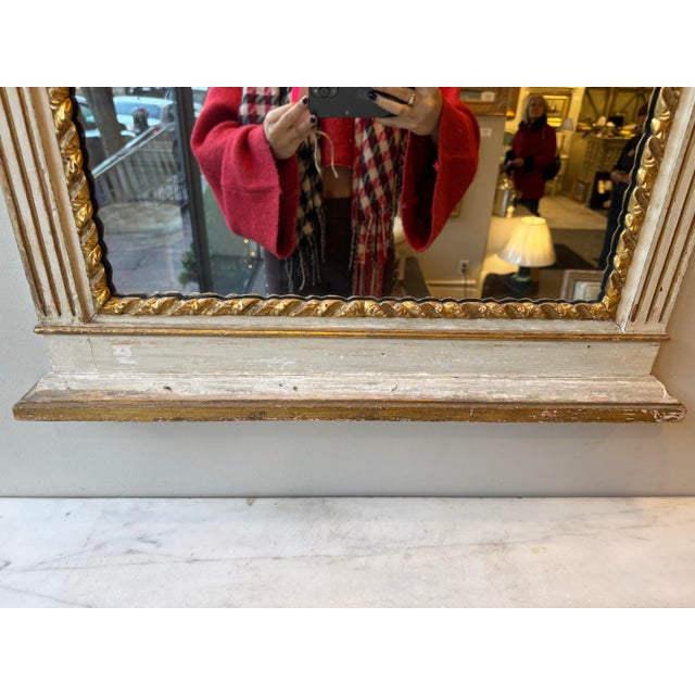 This is a French antique marble top table and mirror set. It has wood painted with gilt. It is perfect for an entry way...