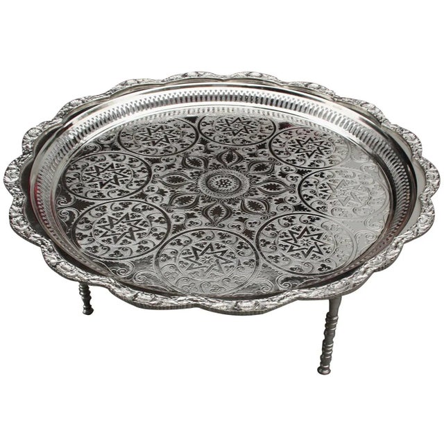 Hand-hammered and engraved tray with Arabesque designs and three detachable feet, crafted in Fez, Morocco. This beautiful...