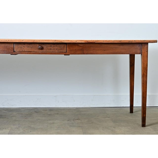 A 19th-century French farm table made from pine and beechwood. The top consists of three long tongue and groove pine...