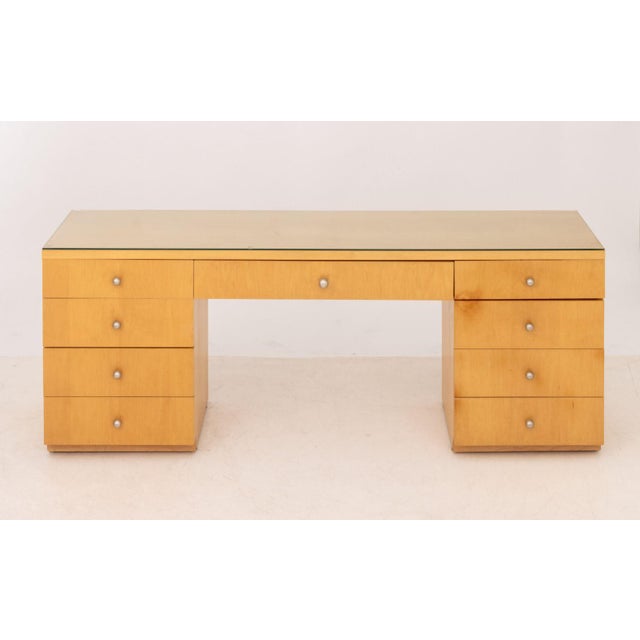 Art Deco Style Blonde Wood Writing Desk, after Donald Deskey (American, 1894-1989), with glass top above central long...