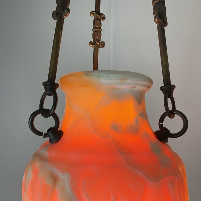 An elegant pair of antique pendant lanterns featuring hand-carved natural onyx shades suspended from finely detailed...
