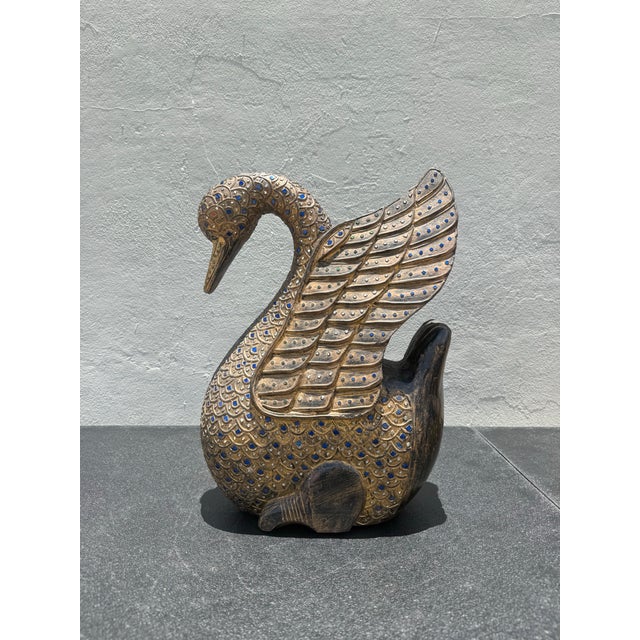 A richly carved folk art swan sculpture featuring hand-worked feather detailing and inset jewel-tone accents throughout....