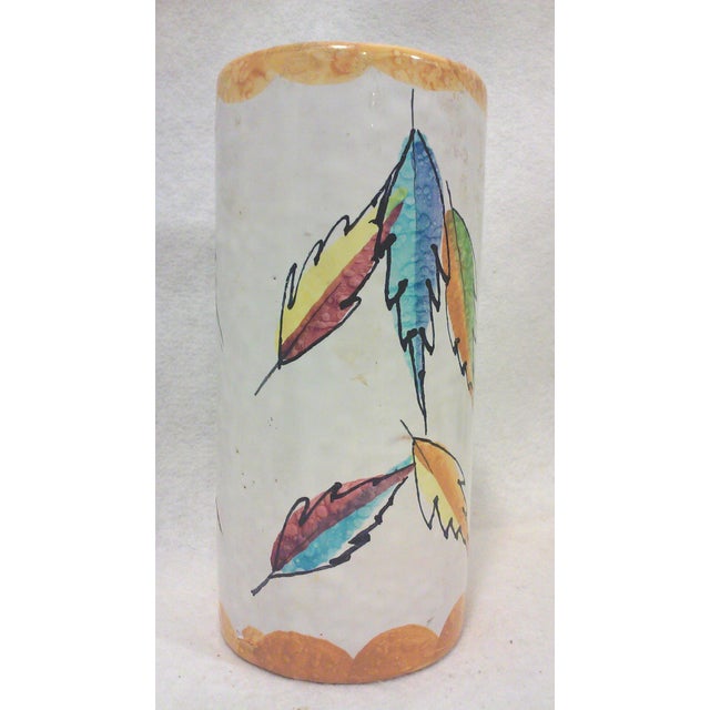 A vintage Italian ceramic cylindrical vase decorated with colorful abstract leaves and a scalloped orange border. This...