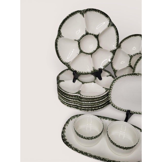 Gien earthenware oyster service, 1960s, with a dark green stamped decoration, comprising 9 plates, 2 platters, 2 serving...