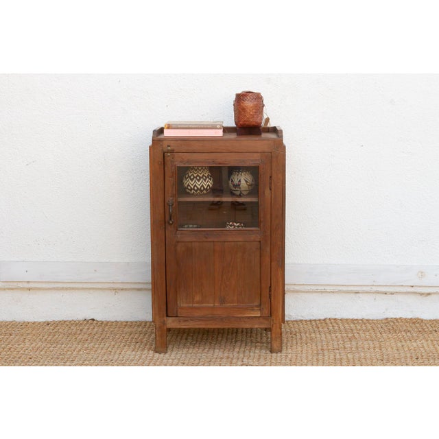 This 38-inch tall cabinet is a prime example of "small-space" colonial utility. Crafted from solid teak with a rich,...
