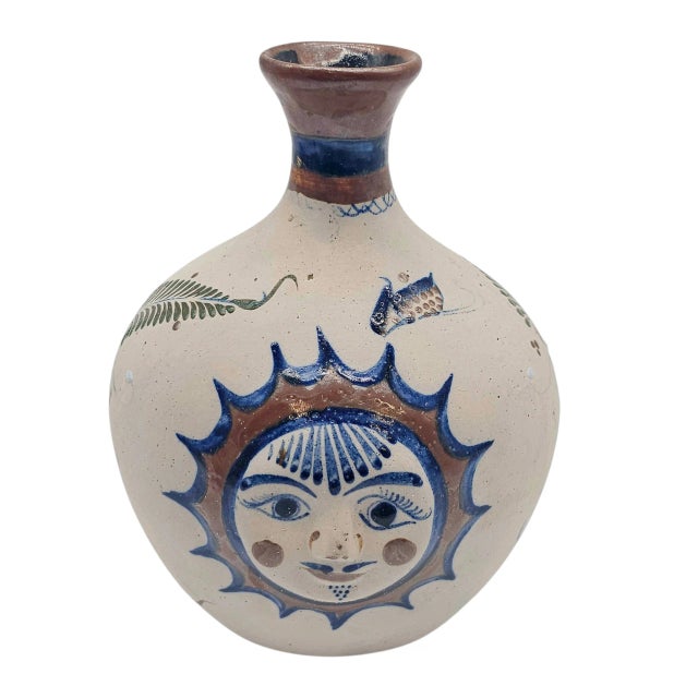 A smiling sun beams from the heart of this Tonalá bottle-form vase, its face both ancient and childlike, like a story...