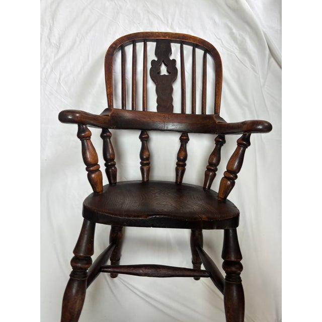 An English Elm and Yew wood Child's Windsor Chair, circa 1840-60, standing only 33" tall and retaining its original crusty...