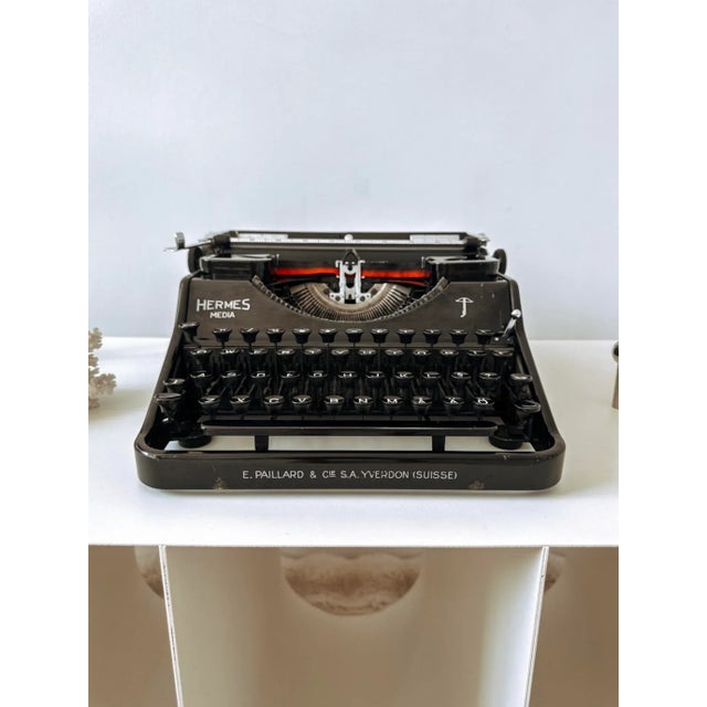This vintage Hermes Media typewriter is more than a writing tool—it’s an elegant design object that captures the spirit of...