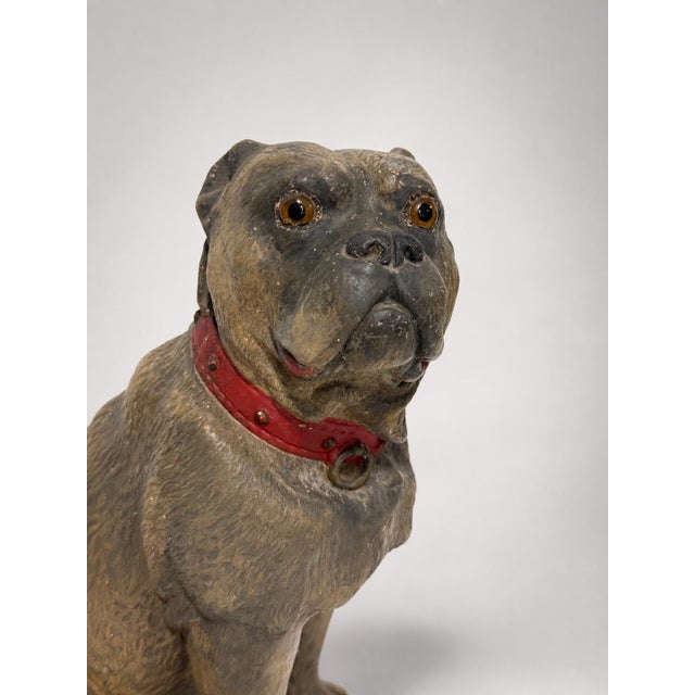 A finely modeled Victorian polychrome terracotta figure of a seated pug dog, naturalistically rendered with an expressive...