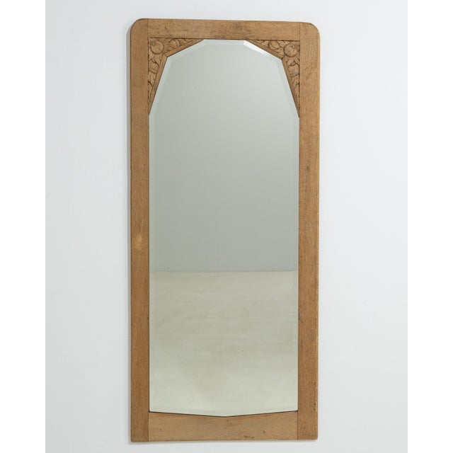 A circa 1920 French wall mirror influenced by the Art Nouveau movement, featuring a tall and elegant vertical format. The...