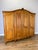 An elegant Vintage French Louis wardrobe crafted in oak, featuring an impressive four-door form, gracefully shaped upper...