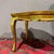 Elegant Venetian-style wooden coffee table, hand-painted, gilded, and lacquered. The shaped tray top is decorated with an...