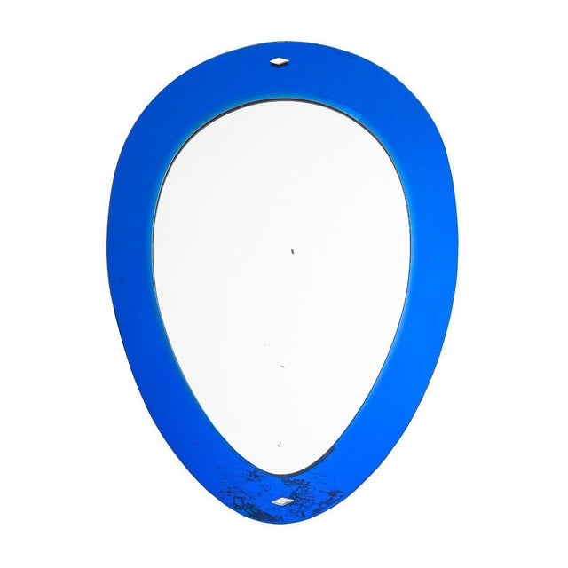 A 1950s Italian oval mirror with a blue glass border. Constructed from two pieces of mirrored glass, the frame and the...