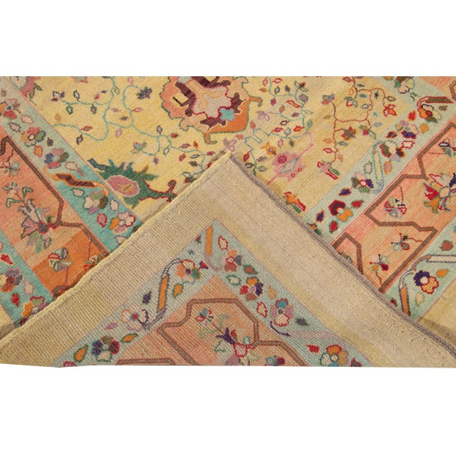 Beautiful Modern hand-knotted wool rug with yellow field. This Revival Collection rug has an orange and blue frame and...