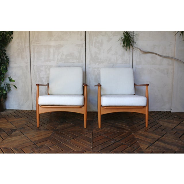 This stunning pair of Mid-Century Danish lounge chairs features a refined blend of teak and beech wood, showcasing the...
