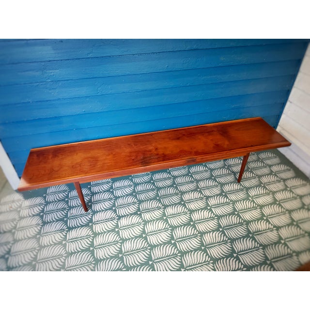 A beautifully crafted long Mid-Century Modern walnut bench showcasing clean Danish Modern lines, sculpted beveled edges,...