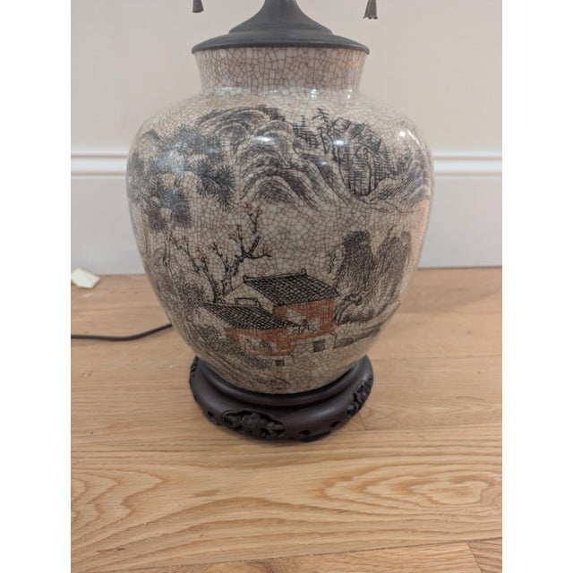This is an antique lamp that has similarities to a ceramic Chinese ginger jar. The base has a crackle glaze with hand...
