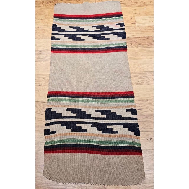 Handwoven by a Native American Navajo (Din�) artisan in the third quarter of the 20th century, this vintage rug carries...