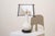 A 1960s vase table lamp. The structure consists of, from bottom to top, a circular, molded black wooden base and a...