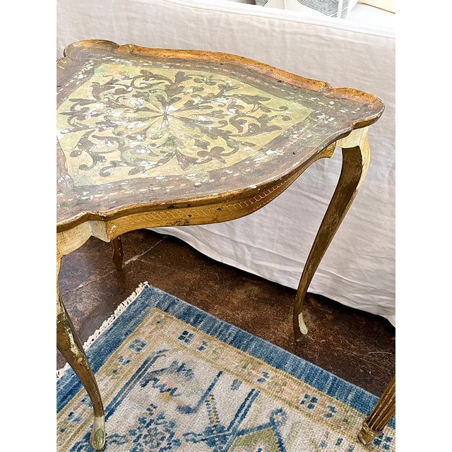 This side table is sturdy yet light. The frame is painted gold, and the top is covered in beautiful Florentine ornamentation.