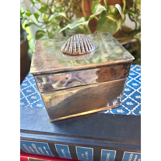 Perfect for the coastal or Palm Beach home, this petite box is silver over copper and has the clam shell motif on the lid....