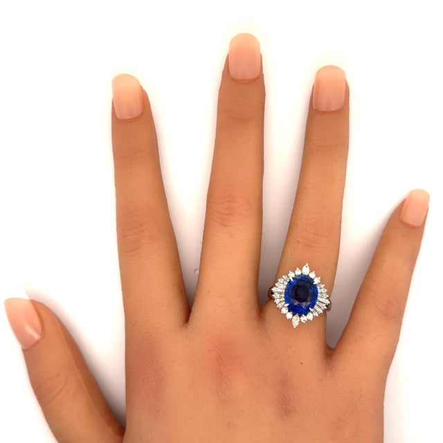 A spectacular sapphire weighing 5.03 carats takes center stage. The sapphire has a rich and intense blue color while still...