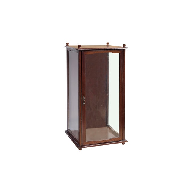 This elegant, miniature display cabinet is crafted from rich, dark-toned wood with a smooth, polished finish that...